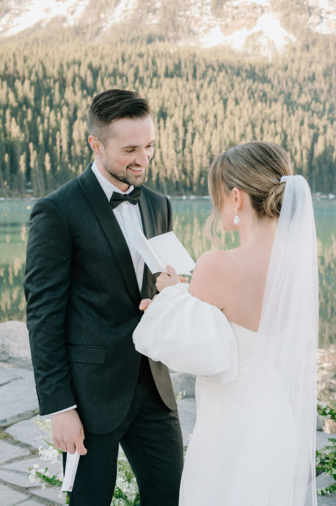 bride-and-groom-exchanging-vows-during-styled-lake-louise-wedding-ceremony-with-mountain-backdrop-banff-wedding-photography