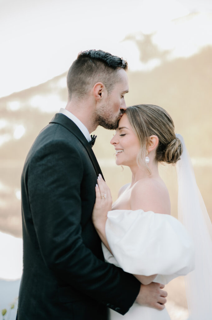 groom-kissing-brides-forehead-close-up-styled-lake-louise-wedding-portrait-banff-wedding-photography