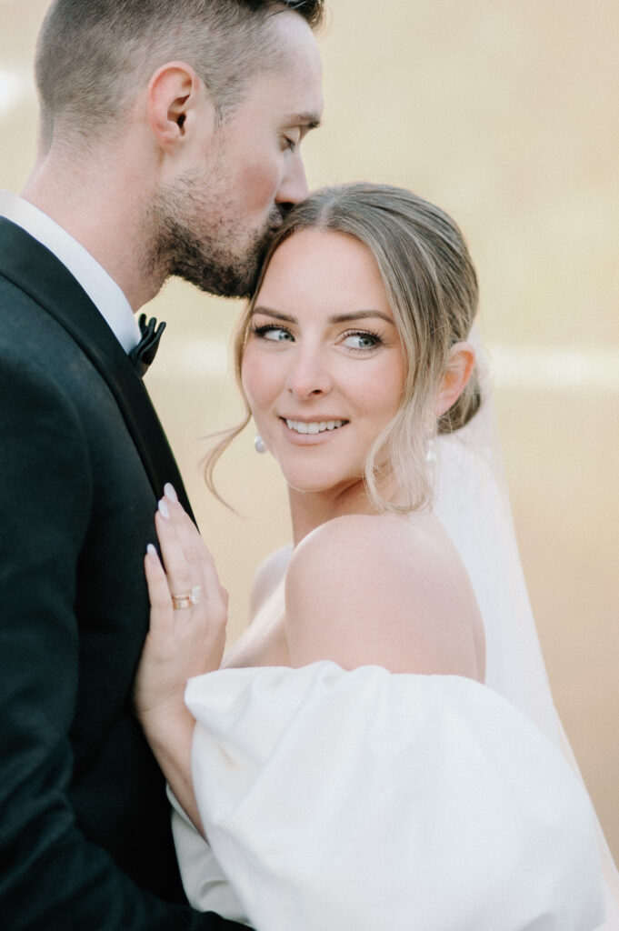 close-up-bride-and-groom-portrait-groom-kissing-brides-forehead-styled-lake-louise-wedding-banff-wedding-photography