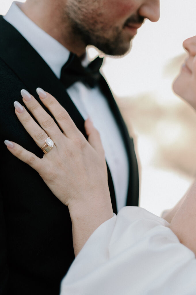 close-up-of-brides-ring-and-hand-on-grooms-tuxedo-styled-lake-louise-wedding-detail-banff-wedding-photography